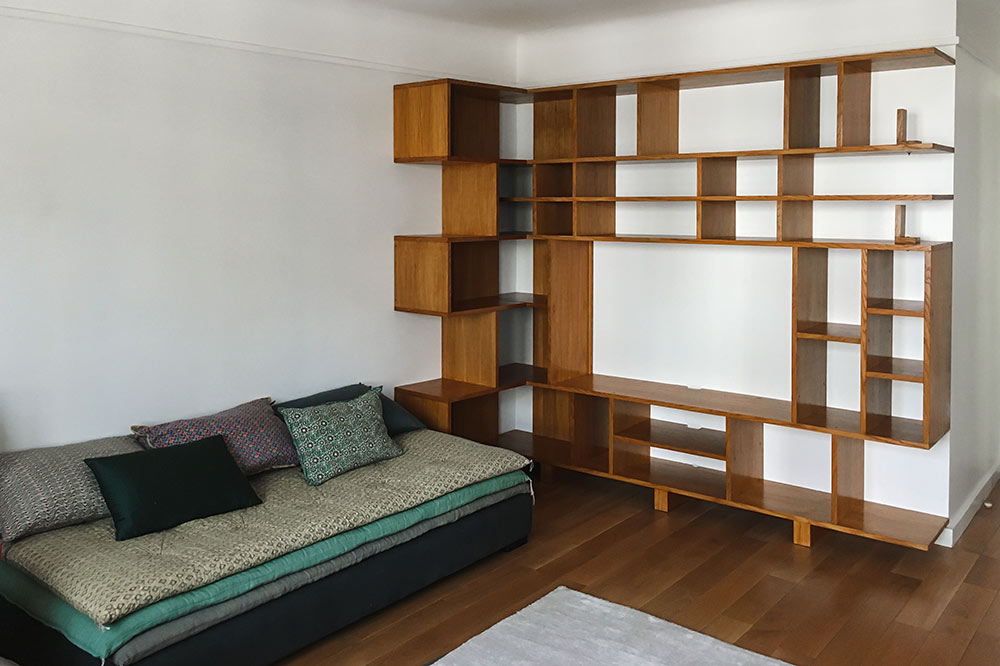 bibliothèque en bois recouvrant un mur composé de plein de niches cubiques et rectangulaires